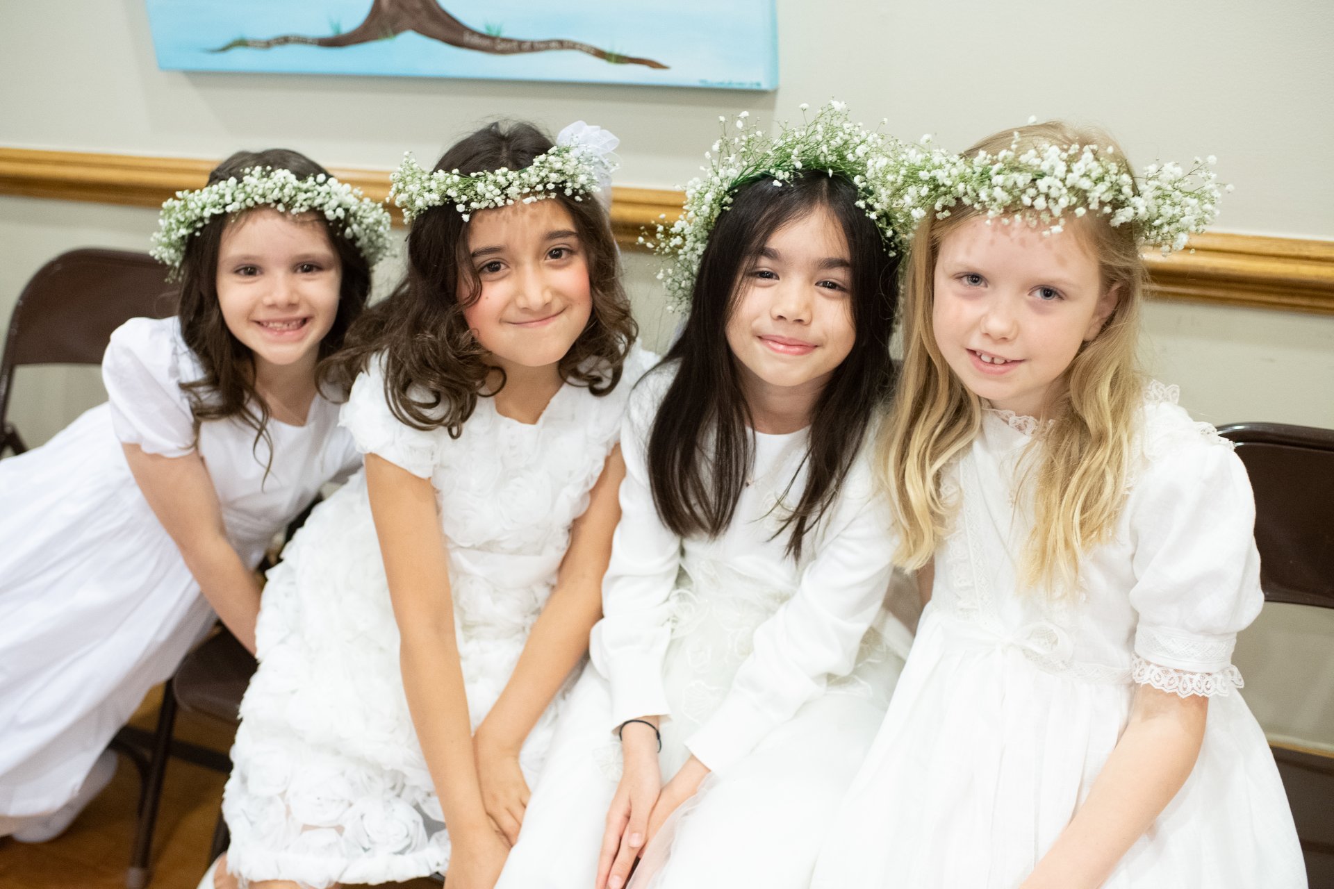 four students in flower crowns and white dresses
