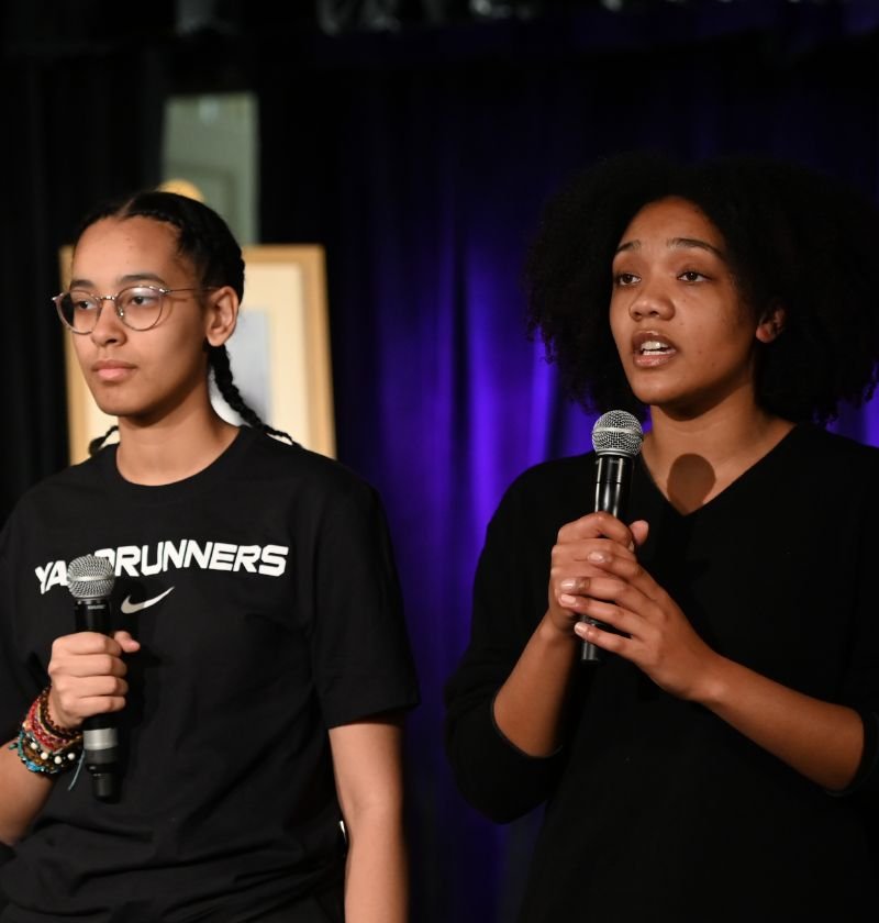 two students speaking on stage