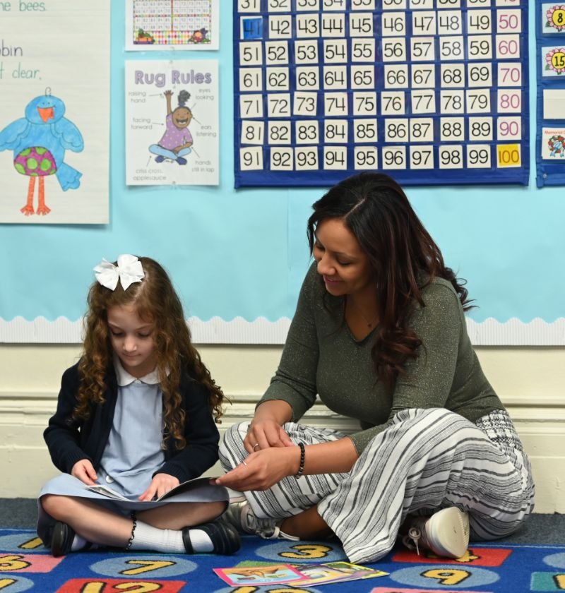 Marymount teacher reading with a student