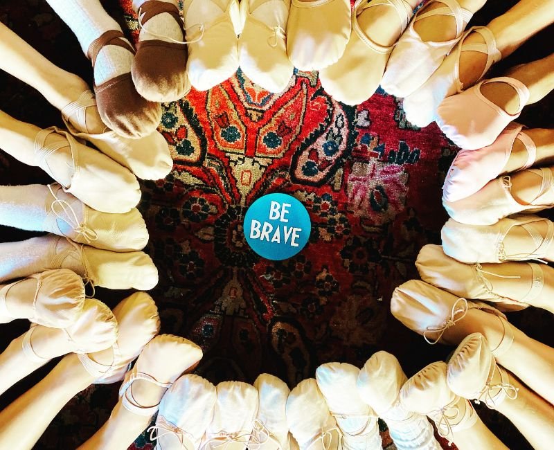 circle of students feet with ballet shoes
