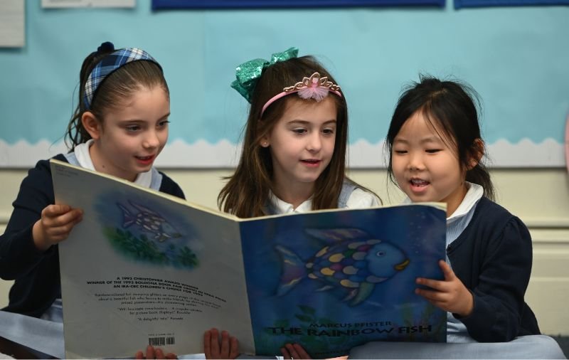 lower school students reading a book
