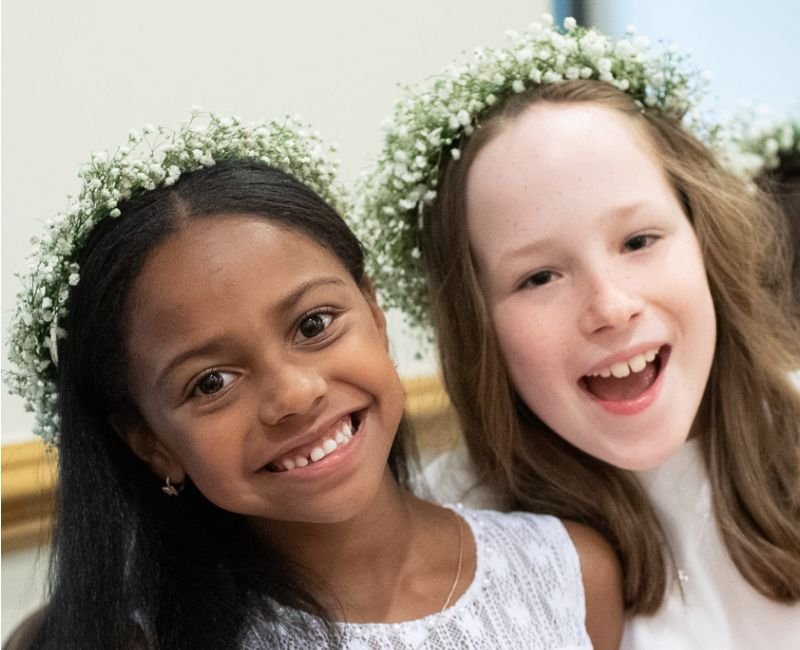 lower school students wearing floral crowns and white dresses