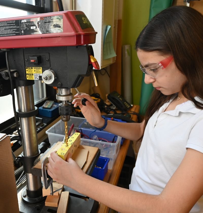 upper middle school student using a drill